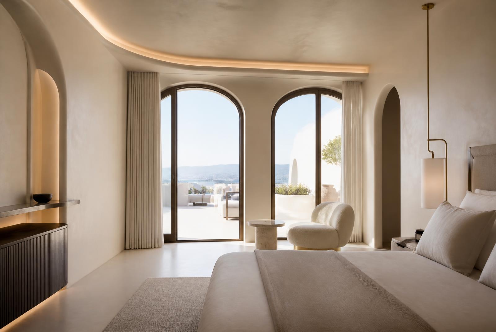The Terrace Suite at The Selah — Gold-framed doors fold back to a walled terrace with an outdoor shower and an olive tree. Inside, a deep tub behind a plaster screen.